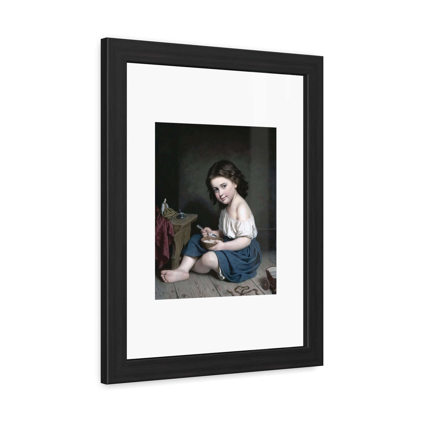 Frukosten wall art featuring a child seated on the floor, holding a toy, framed in black.